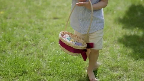 Easter egg hunt: barefoot child searching colorful Easter eggs hidden in grass Stock Footage 234931132