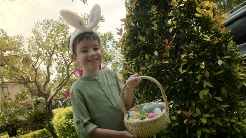 Easter Egg Hunt. Child collects Easter eggs and girl puts in a basket. Colorful Stock Footage 304815696