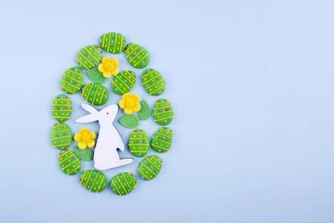 Easter egg made of sugar candy eggs, bunny on blue background. Fotos de archivo