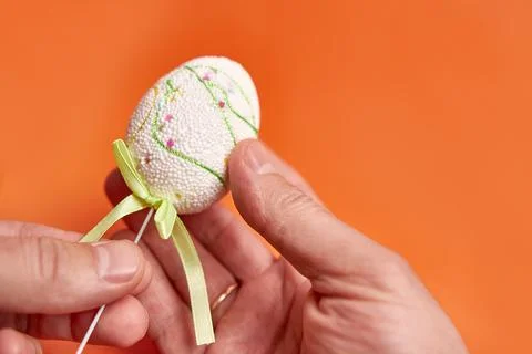 Easter egg on an orange background. A place for information. Stock Photos