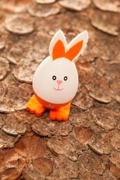Easter egg in orange on a tree bark Stock Photos