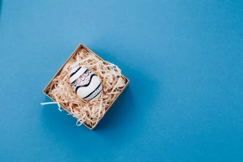 The Easter egg is painted in black and white, an abstraction, lies in a box. Stock Photos