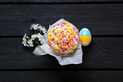 Easter egg with painted Ukrainian flag, kulich and blossoming cherry branch.. Stock Photos