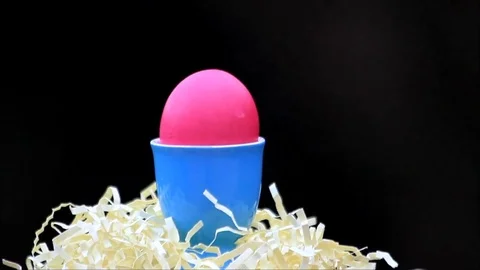 Easter Egg pink in blue egg cup, black background Video stock 76095007