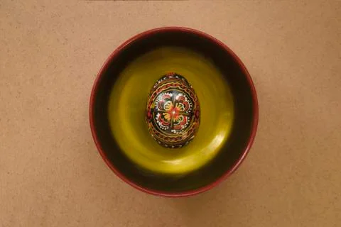 Easter egg on a plate painted in black with a handmade pattern. Closeup view  Stock Photos