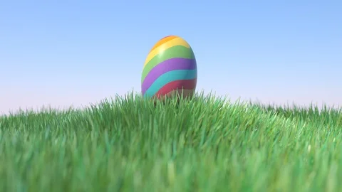 Easter Egg rainbow colored on green grass hill, slow zoom Vídeo Stock 102313298