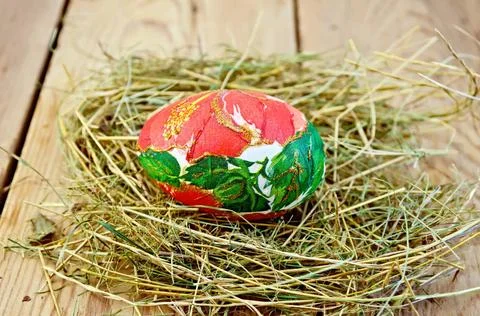 Easter egg with a red flower in the hay Easter egg with a pattern of red f... Stock Photos