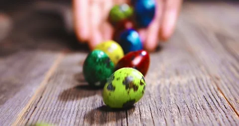 Easter Egg Roll. Close up video of colorful eggs rolling on wooden table from 動画素材 150957312