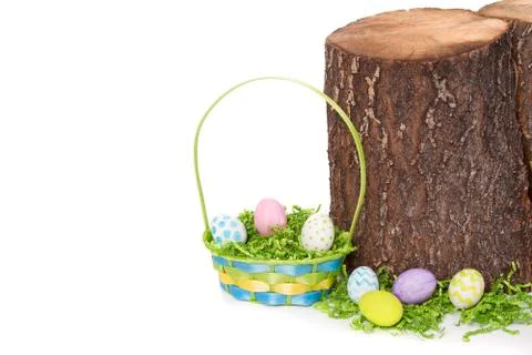 Easter eggs and basket by tree stump Stock Photos