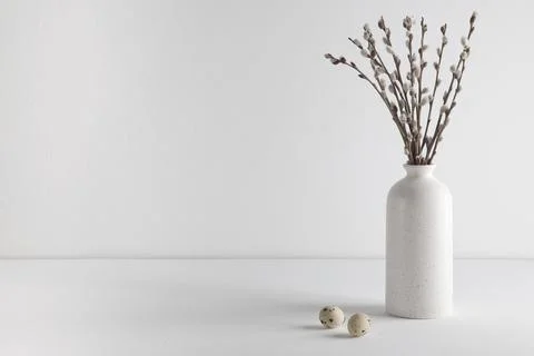 Easter eggs and a bouquet of willow trees in a vase on a white background. Space Stock Photos