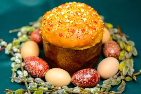 Easter eggs and bread on a dark background with willow branches background. Stock Photos