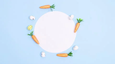 Easter eggs and carrots appear around paper card note. Minimal stop motion Stock Footage 149932152