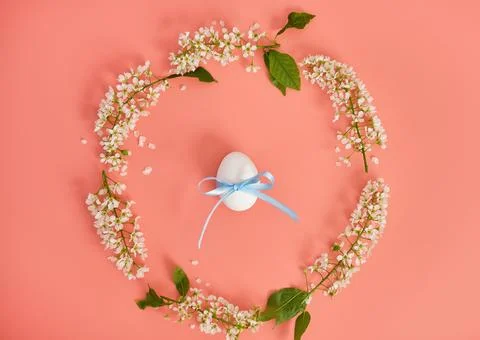 Easter eggs and cherry branches in the shape of a circle on a pink background Stock Photos