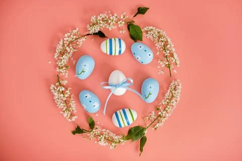 Easter eggs and cherry branches in the shape of a circle on a pink background Stock Photos