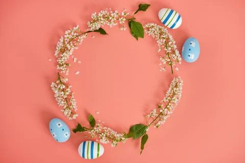 Easter eggs and cherry branches in the shape of a circle on a pink background Stock Photos