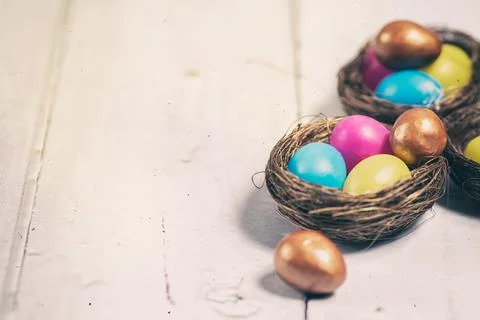 Easter eggs and chocolate eggs in nests Stock Photos