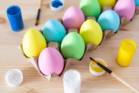 Easter eggs and colored paints on the table for holiday craft. Stock Photos