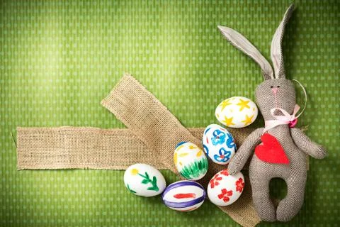 Easter eggs and easter bunny lie on a green background Stock Photos