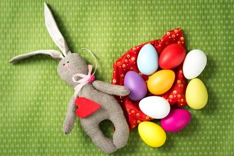 Easter eggs and easter bunny lie on a green background Foto stock