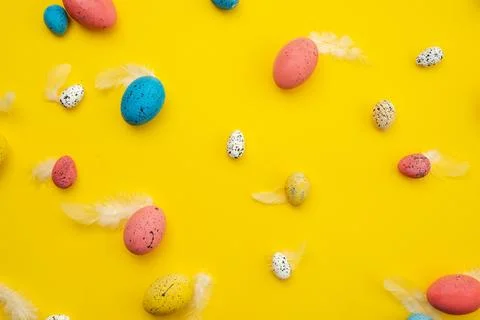 Easter eggs and feathers on yellow background. Easter card Stock Photos