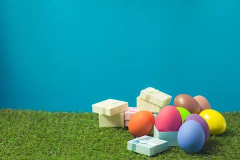 Easter eggs and gift box on the green grass. Stock Photos