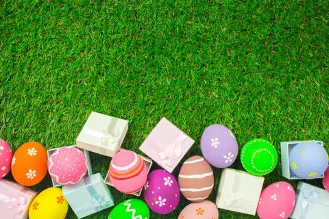 Easter eggs and gift box on the green grass. Stock Photos