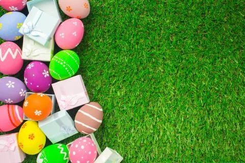 Easter eggs and gift box on the green grass. Stock Photos