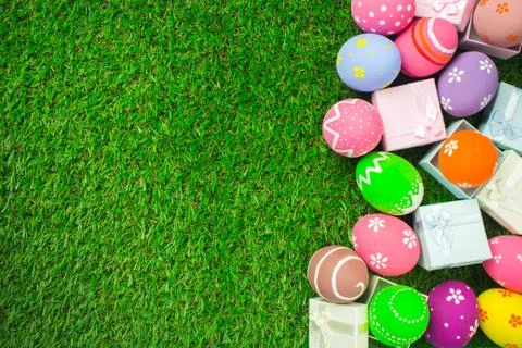 Easter eggs and gift box on the green grass. Stock Photos