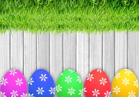 Easter eggs and green grass over white wooden table Фото