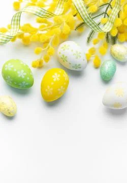 Easter eggs and mimosa creating spring holiday background Stock Photos