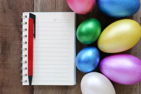 Easter eggs and note book on wood background. Stock Photos