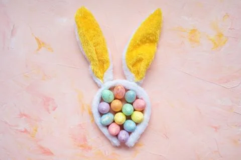Easter eggs and rabbit ears on pink background Stock Photos