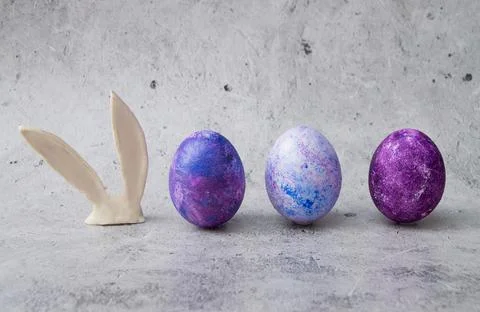 Easter eggs and rabbit ears on a gray marble background. A postcard with a place Stock Photos