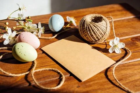 Easter eggs and spring blossoms arranged with twine and kraft paper on wood Stock Photos