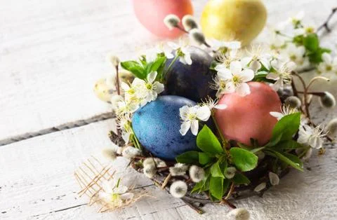Easter eggs and spring flowers on a white wooden background. Copy space. Foto stock