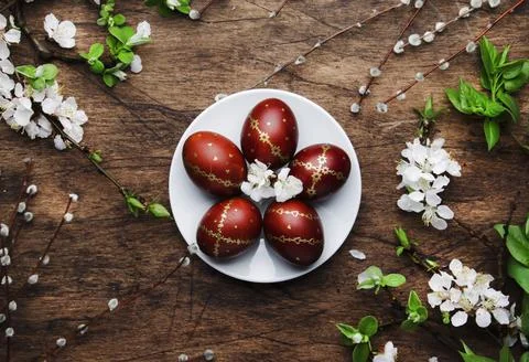 Easter eggs and spring white flowers and willow branches on Easter wooden bac Stock Photos