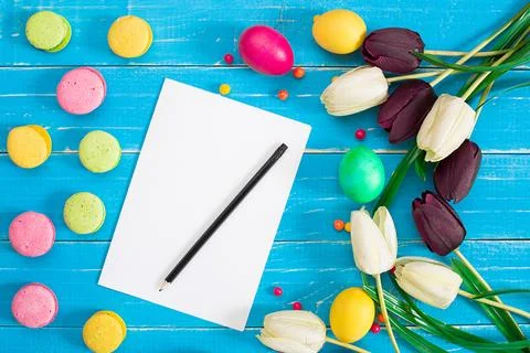 Easter eggs and tulips on blue wooden planks Stock Photos