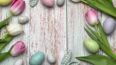 Easter eggs and tulips forming a border on rustic white wood Stock Footage 304975931