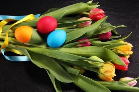 Easter eggs and tulips on rustic table Stock Photos