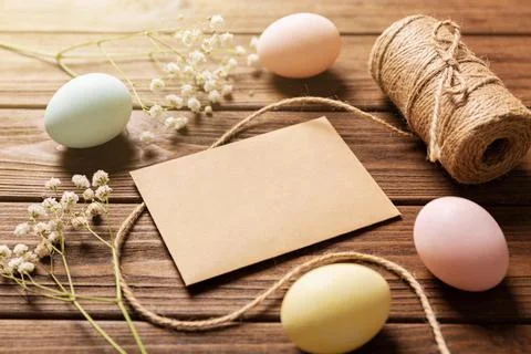 Easter eggs and twine on rustic wooden table with blank card and delicate f.. Stock Photos