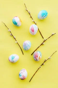 Easter eggs and willow branches on a yellow background Stock Photos
