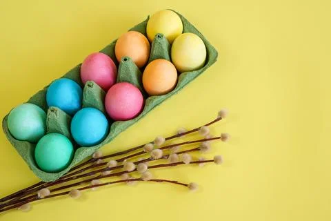 Easter eggs and willow branches on a yellow background Stock Photos