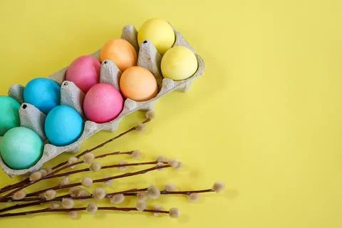Easter eggs and willow branches on a yellow background Stock Photos