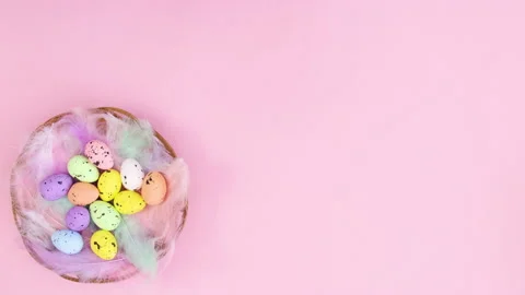 Easter eggs appear in basket with feathers on left side. Stop motion Stock-Footage 147751354