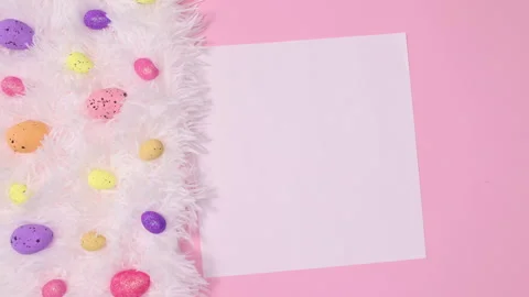 Easter eggs appear on fur and paper card note on pink background. Stop motion Stock Footage 150075033