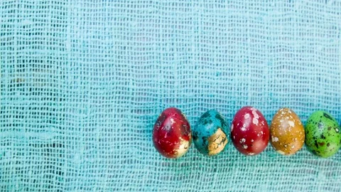 Easter eggs are laid out in a row on a cloth lilac. Stock Footage 86765701