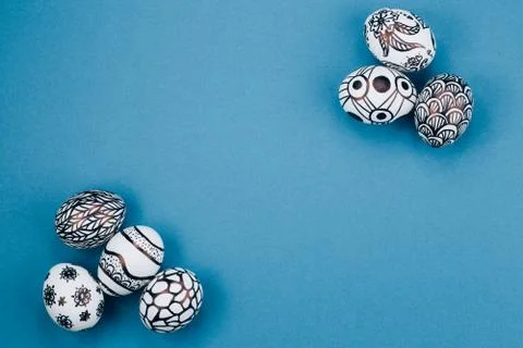 Easter eggs are painted in black and white lie in the corners diagonally. Stock Photos
