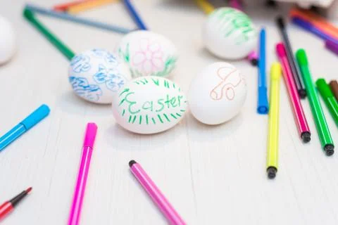 Easter eggs are on the table with colored felt-tip pens. Stock Photos