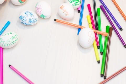 Easter eggs are on the table with colored felt-tip pens. Stock Photos