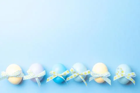 Easter eggs background. Colourful egg with tape ribbon on pastel blue backgro Stock Photos